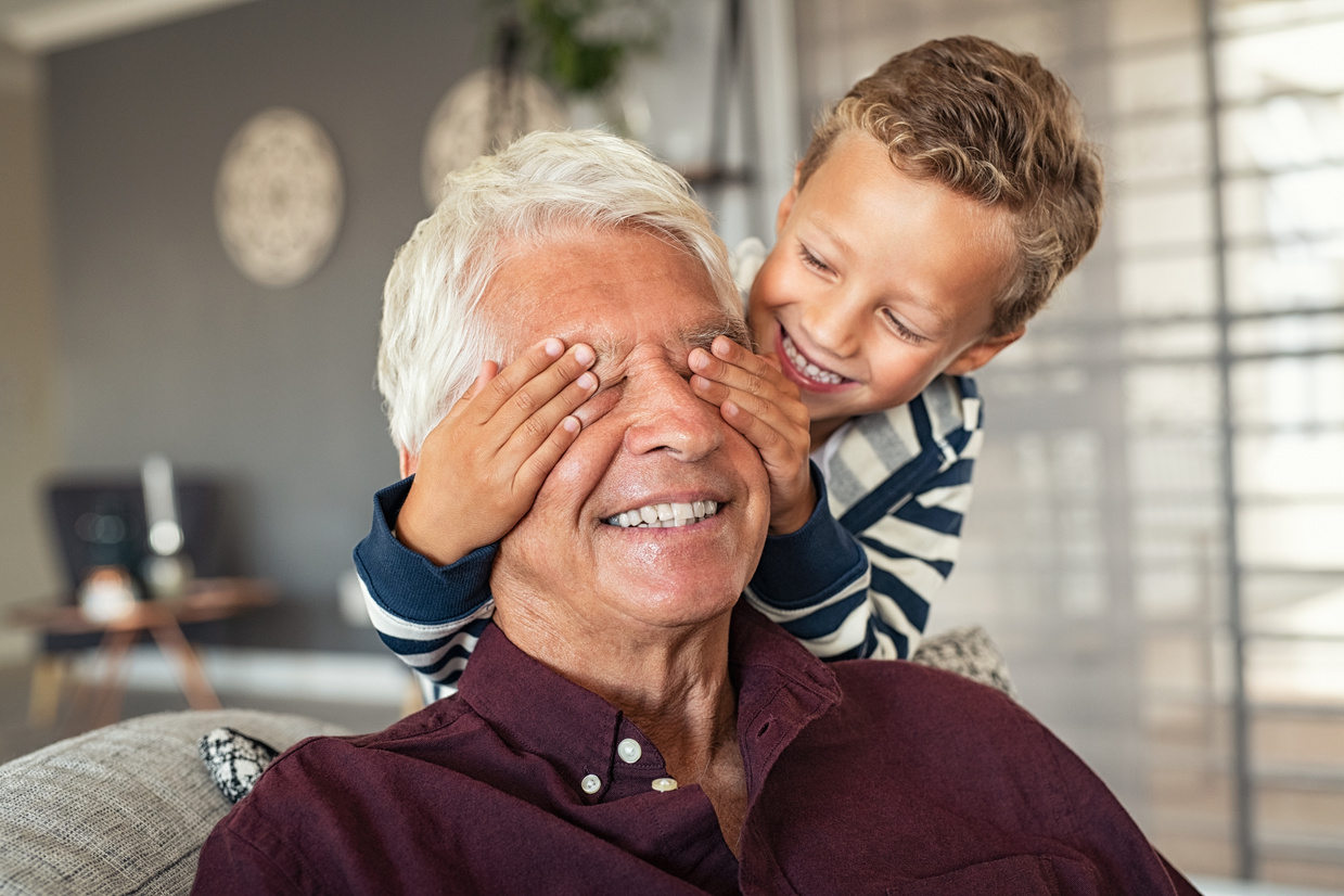 Boy Covering His Grandpa's Eyes