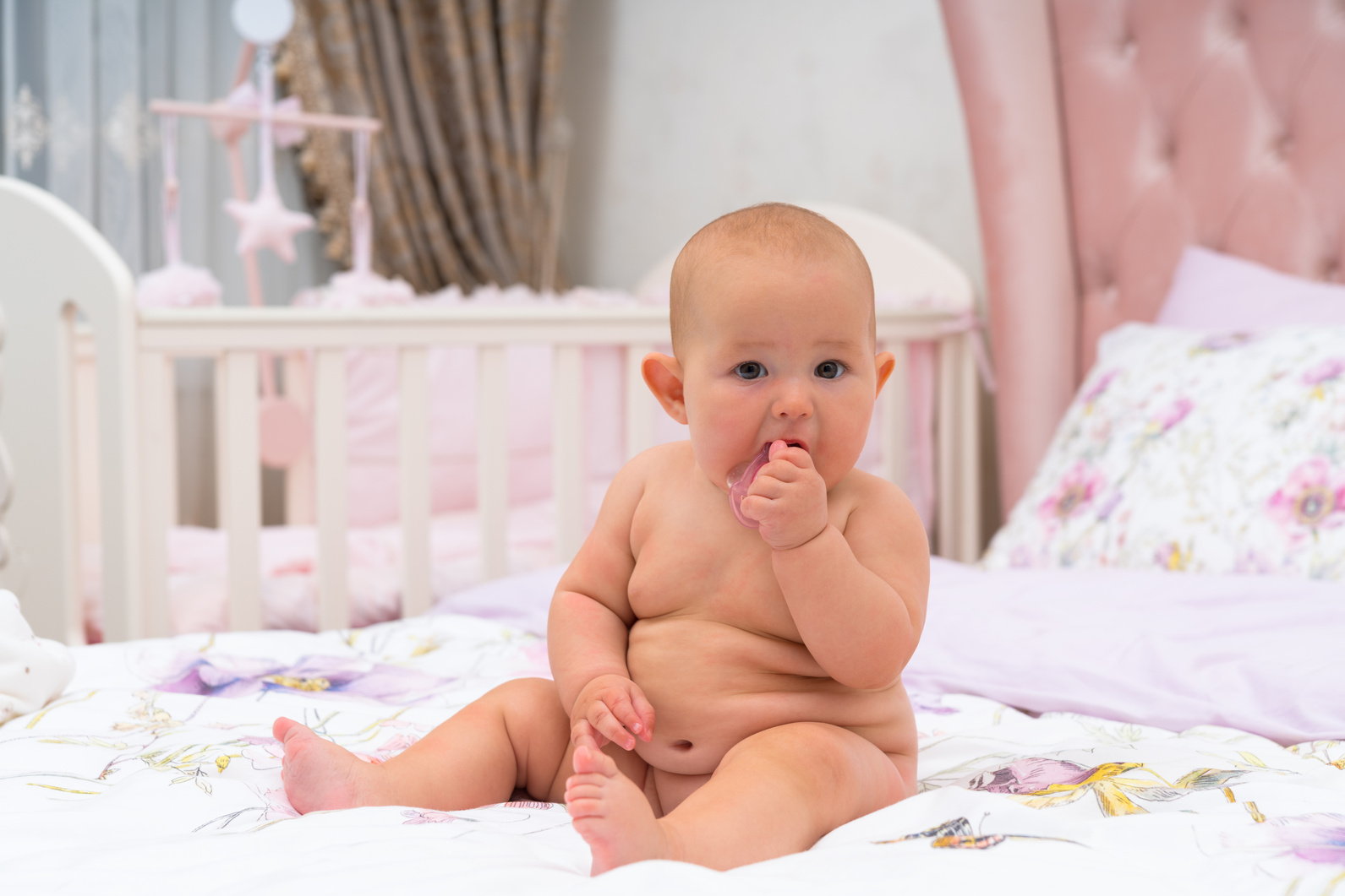 Chubby Naked Baby in Pink Room Looking at Camera
